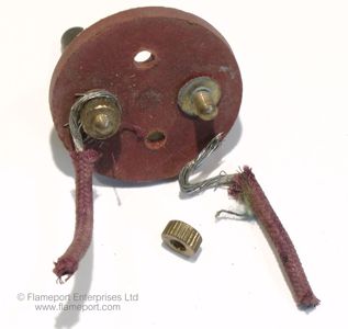 Red fibre disc with two brass terminals from a wooden plug