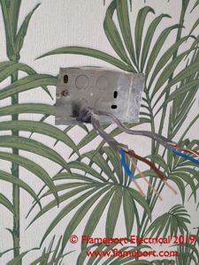 Metal 35mm backbox in a wall with leaf pattern wallpaper